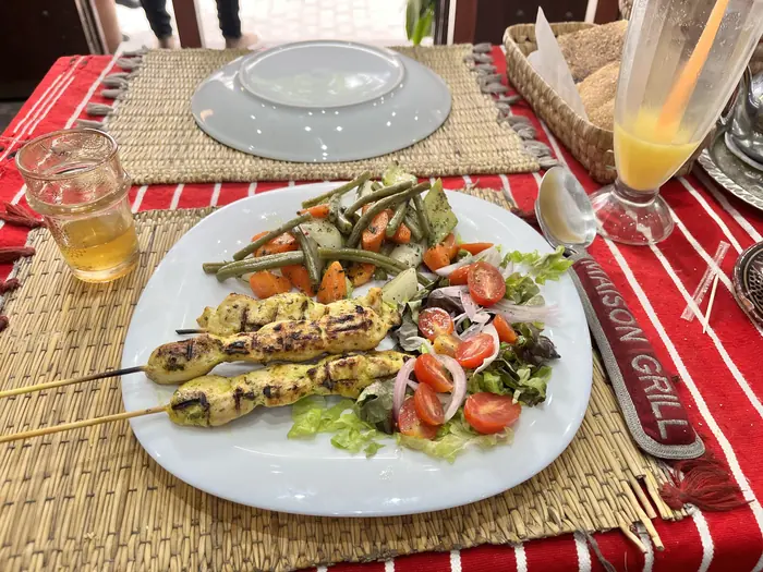 Deux brochettes de poulet mariné, salade et légumes de saison dans l'assiette