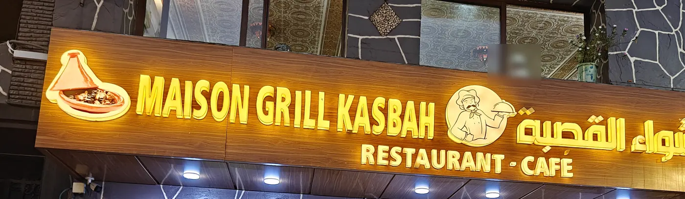 L'enseigne allumée de Maison Grill Kasbah, le soir, rue de la Kasbah